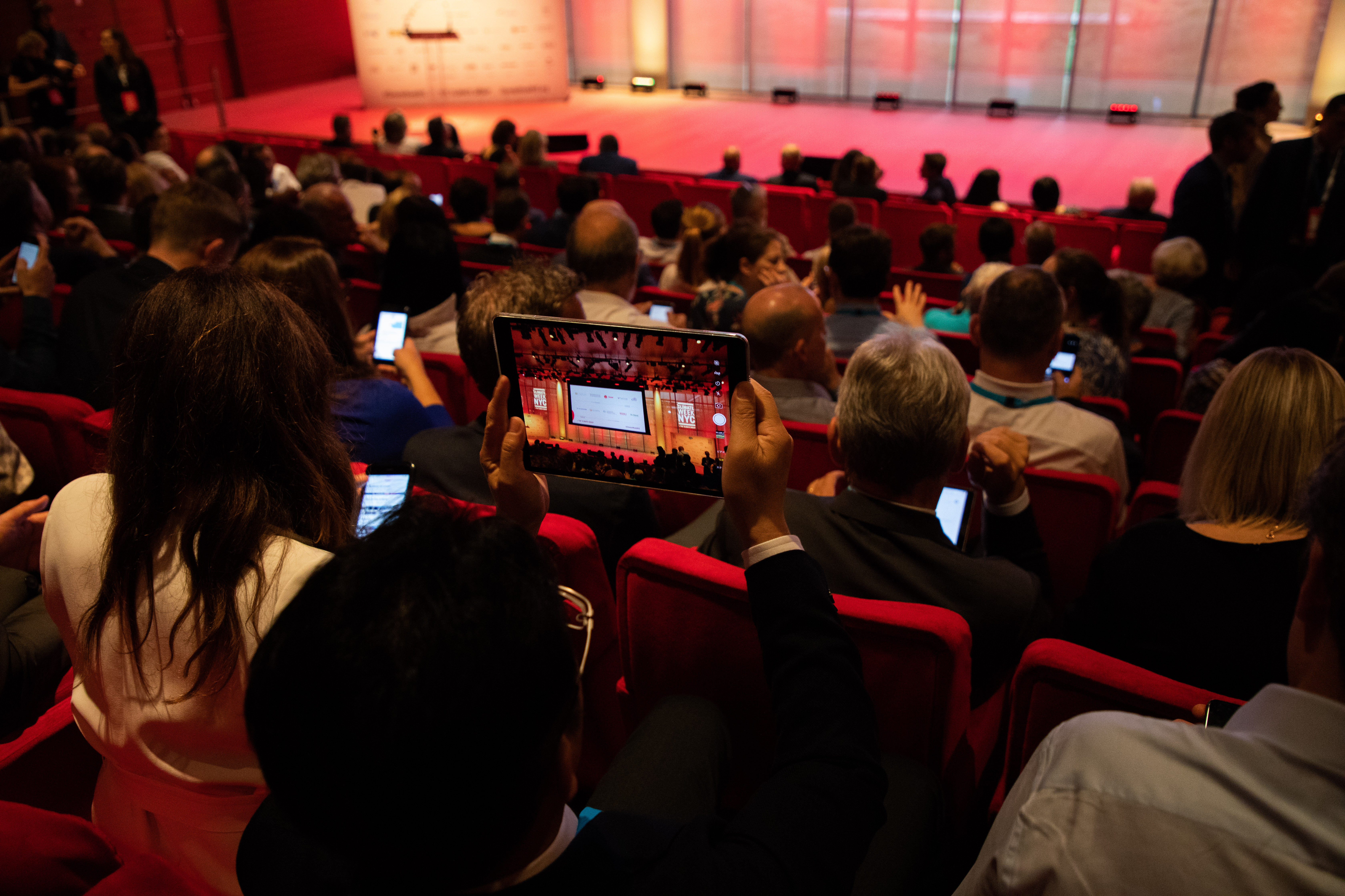 Climate Week NYC audience member watches stage on ipad